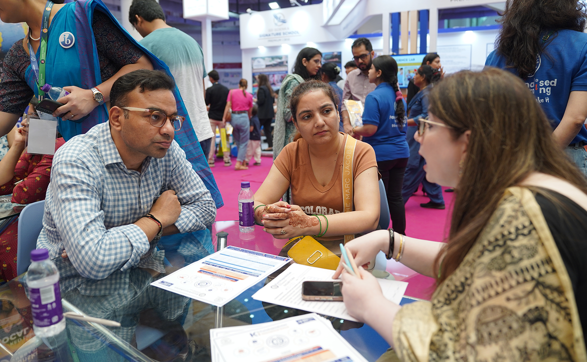 Parents interacting with school representatives during a school admission event.